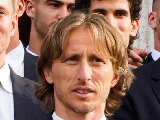Luka Modric i kostym under Real Madrids titelfirande i Madrid, omgiven av lagkamrater